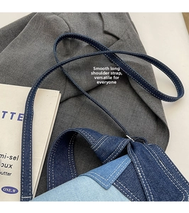 Gros plan détaillé du sac bandoulière en denim avec patchwork bleu et surpiqûres blanches