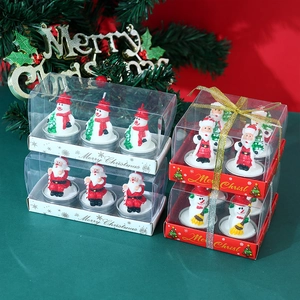 Close-up of Christmas candle gift sets featuring Santa Claus and snowman wax figures