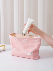 Beauty case rosa trapuntato con fiocco ricamato bianco e chiusura a zip in metallo