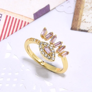 Golden eye-shaped open ring featuring pink rectangular zircons and pave crystals