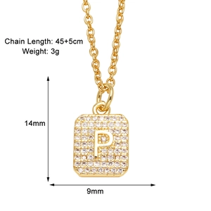 Macro shot of gold square pendant with cubic zirconia and letter P detail on chain