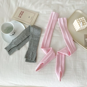 Detailansicht gestrickter Beinstulpen im Ballett-Stil in Rosa und Grau-Tönen