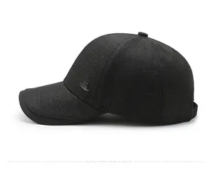 Side view of dark charcoal grey baseball cap with textured fabric and small metal logo
