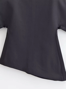Vue détaillée de l'ourlet asymétrique de ce haut noir élégant à manches bouffantes pour femme