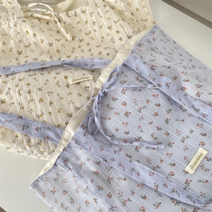 Detailed close-up of floral pleated tote bags with brand label and textured fabric