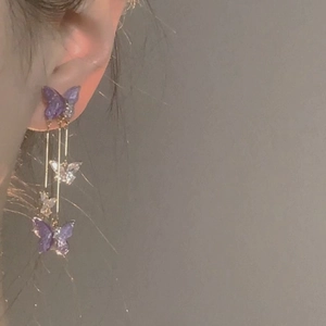 Long purple butterfly tassel drop earrings featuring four cascading butterflies on model