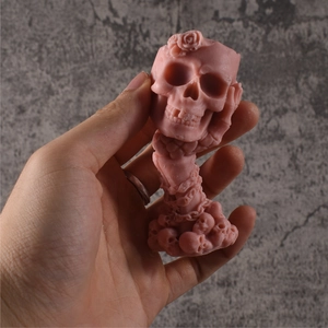 Hand-held pink gothic skull candle mold with detailed roses and chain texture