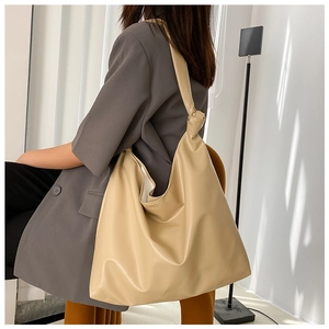 Side view of large khaki PU leather tote bag on shoulder for casual styling