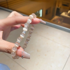 Detailed close-up of a chalcedony bead bracelet with a silver crystal butterfly charm