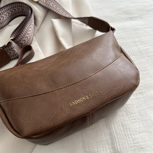 Borsa a tracolla retrò in finta pelle marrone con ampia tracolla a motivi su fondo chiaro