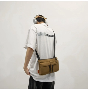 Close-up of khaki nylon messenger bag with two front pockets and adjustable strap