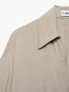 Detail of embroidered khaki linen shirt collar and fine stitching on the shoulder area