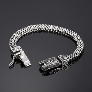 Macro detail of men's vintage titanium steel bracelet with Viking skull carvings