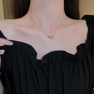 Detail of rose gold double interlocking ring necklace with pavé zircon on model