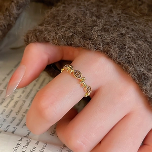 Detailed view of vintage gold-plated ring featuring elephant and coin motifs on finger