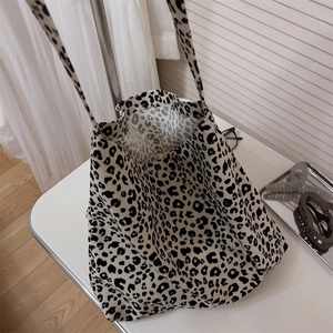 Dettaglio della borsa tote in tela con stampa leopardata su un tavolo bianco