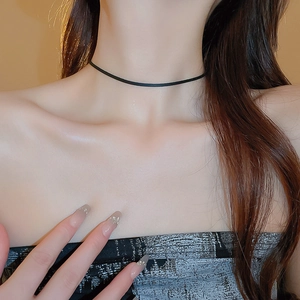 Close-up of a minimalist black faux leather choker necklace on a female model neck
