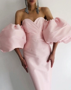Detail of elegant pink off-shoulder dress with oversized puff sleeves and satin finish