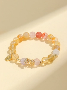 Detailed close-up of a beaded bracelet with purple amethyst and golden snake charm