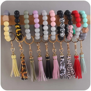 Detail of colorful silicone beaded bracelets with leather tassels and gold metal clasps