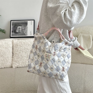Détail du sac en toile matelassé avec motifs d'ours et surpiqûres en losanges bleus