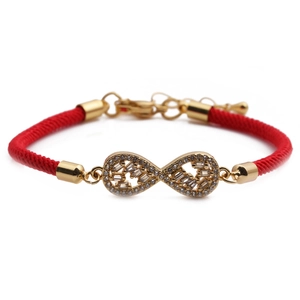Detail of red braided infinity bracelet with gold-plated charm and sparkling zircons