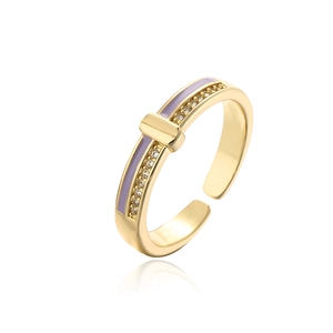 Macro view of gold-plated open ring with purple enamel and cubic zirconia details