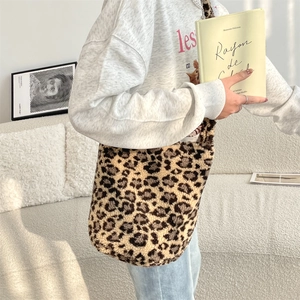 Close-up of leopard print plush tote bag worn by a model in a minimalist home setting