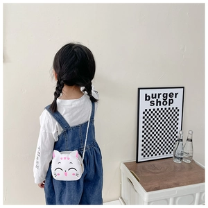 Girl wearing a cute white cat-shaped crossbody bag in a clean minimalist indoor setting