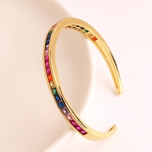 Detail van een gouden C-vormige open armband met micro-pave veelkleurige zirkonia