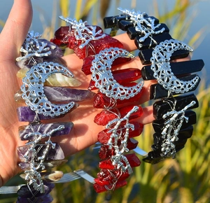 Detail of three handmade cat-ear crystal crowns with moon and branch accents