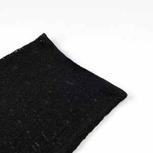 Gros plan sur un tissu en dentelle noire aux motifs floraux détaillés et texture fine