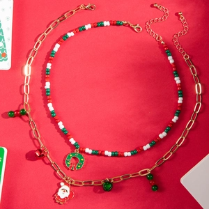 Detail of Christmas beaded necklace and gold chain with Santa and wreath charms