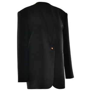 Close-up of black blazer jacket featuring single-breasted design and a golden button detail
