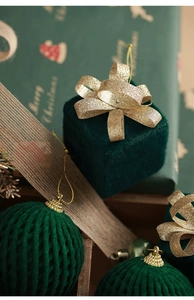Detail of dark green flocked Christmas ball ornaments with gold glitter accents