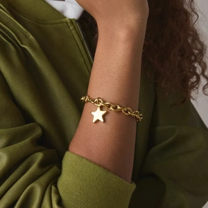 Elegant gold-plated stainless steel star pendant bracelet on female wrist with chunky chain link