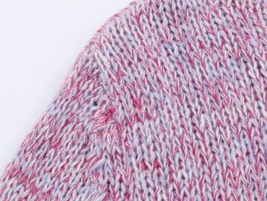 Macro shot of mixed pink and blue yarn texture with detailed stitching on a knit sweater