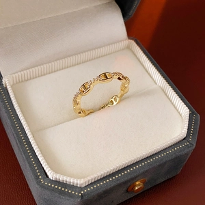 Makroaufnahme von vergoldetem Schweinenasen-Ring mit Zirkonia-Inlay in einer Schmuckschatulle
