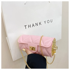 Detailed view of pink quilted cylinder mini bag with gold chain and metal clasp