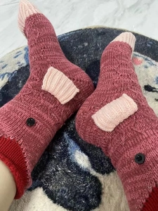 Macro detail of thick knitted winter crocodile socks with funny meat texture and buttons