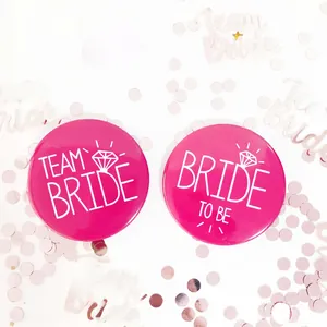 Gros plan de badges roses Team Bride et Bride to Be pour enterrement de vie de jeune fille