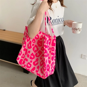 Pink leopard print canvas tote bag shown on a model in a bright modern room