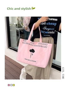 Detail of pink canvas tote bag showing black floral print and NKK ART STUDIO text
