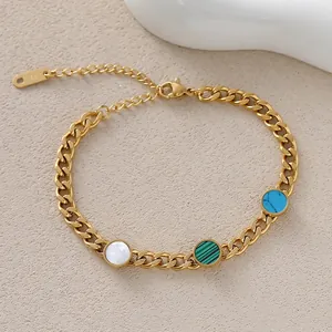 Close-up of golden chain bracelet featuring green, blue, and white circular stone inlays