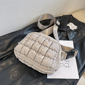 Close-up of beige quilted puffer belt bag with soft nylon texture and adjustable strap