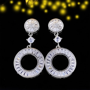 Detail shot of silver drop earrings with clear cubic zirconia pavé on a circular pendant