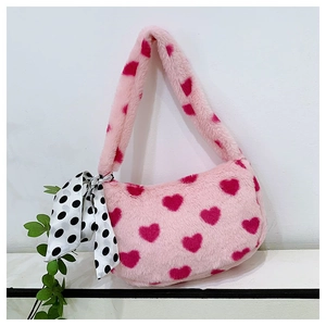 Close-up of pink faux fur shoulder bag with red hearts and a polka dot silk scarf