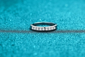Macro detail of silver ring featuring channel-set round cut moissanite stones