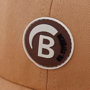Minimalist cotton baby baseball cap in brown featuring a round 3D letter B rubber patch