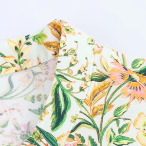 Detailopname van bloemenprint halslijn en schoudernaden op een midi-jurk